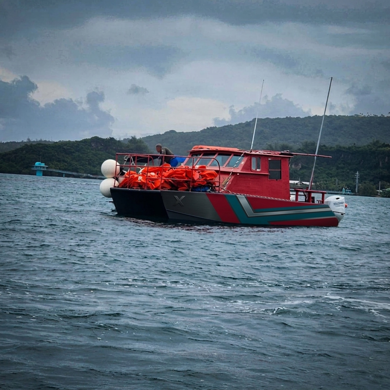 Aluminum workboat hauling cargo in a Guam harbor